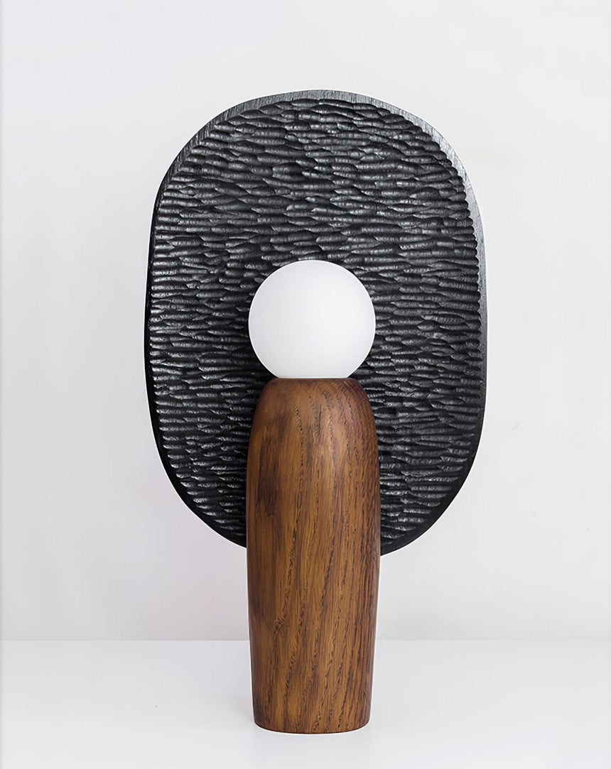 Front view of the charcoal backplate table lamp lit on a plain white ground
