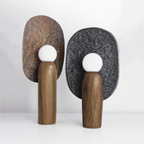 Bronze and charcoal totem table lamps side by side seen from an angle