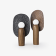 Two totem table lamps with carved backplates and opal globes on a plain ground