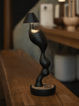 Matte black cordless table lamp on a wooden bench in a kitchen