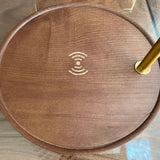 Angled close view of the walnut base showing the charging symbol and pole