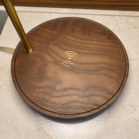 Close view of the charging symbol engraved in the center of the walnut base
