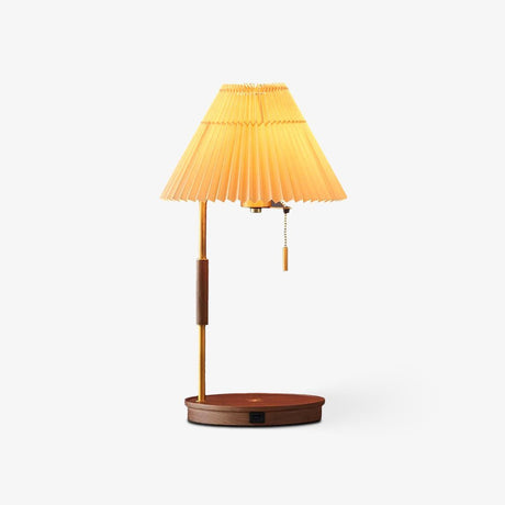 Table lamp with a pleated beige shade on a brass pole and a walnut disc base