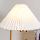 The pleated shade lit from inside, the folds reading as fine vertical lines