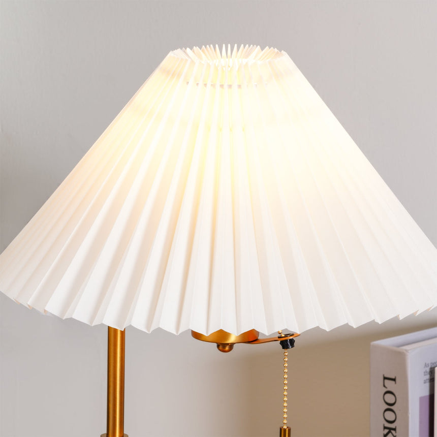 The pleated shade lit from inside, the folds reading as fine vertical lines