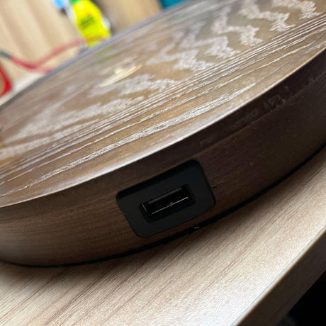 Close view of the USB port set into the rim of the walnut lamp base