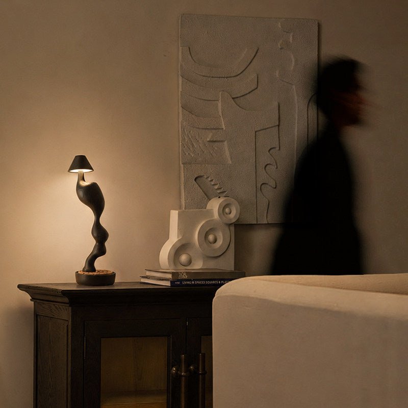 Cordless carved wood table lamp lit on a cabinet in a dim hallway