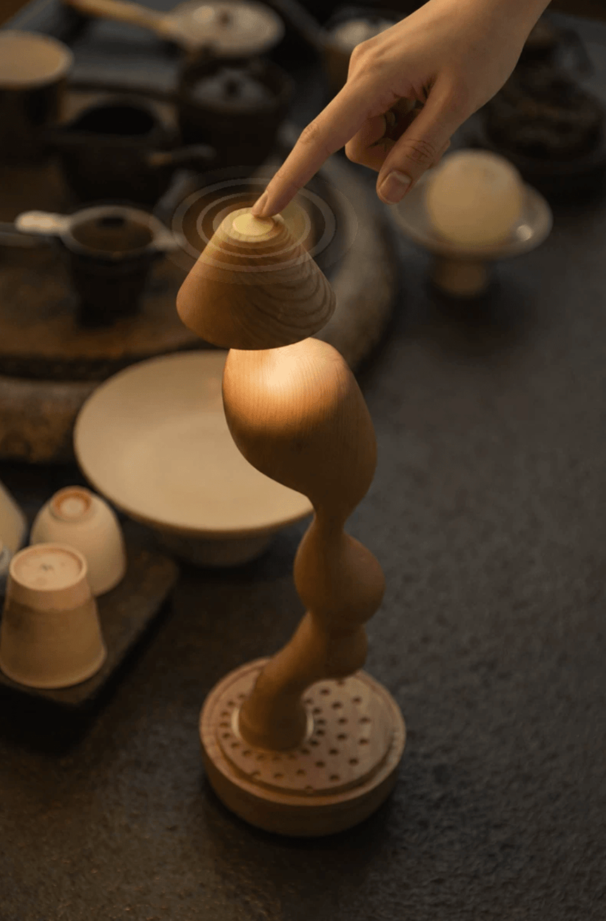 Cordless carved wood table lamp lit on a cabinet in a living room