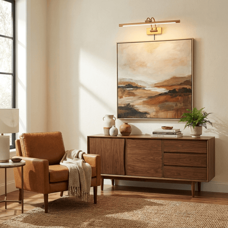Brass bar lit over an abstract canvas above a walnut sideboard in a sunlit living room