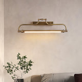 Bracket lit on a plaster wall above a plant and a low couch in a warm room