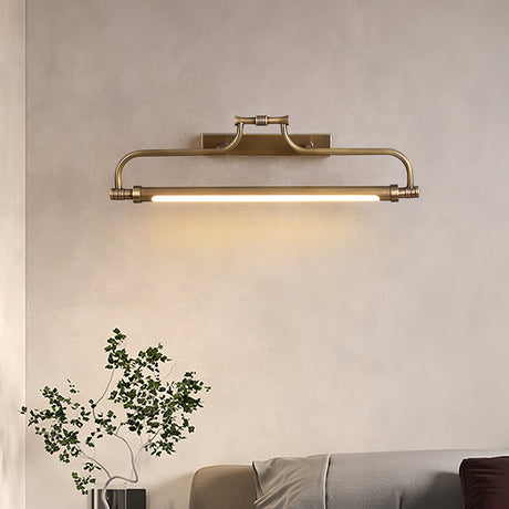 Bracket lit on a plaster wall above a plant and a low couch in a warm room
