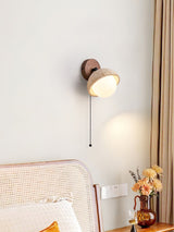 Single dome lit beside a cane headboard above a vase of dried flowers