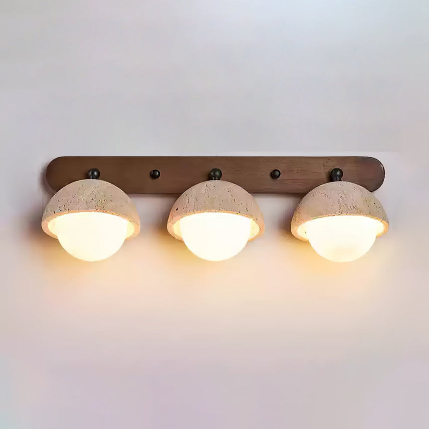 Three travertine domes in a row on a walnut bar with all three orbs lit