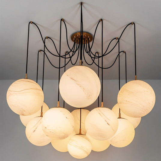 The same globes lit on black arms, spread wide below a round ceiling plate