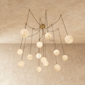 Alabaster globes lit on long brass arms that curve down from a central plate