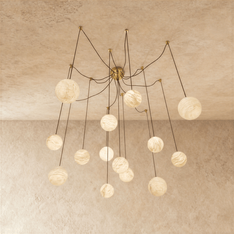 Alabaster globes lit on long brass arms that curve down from a central plate
