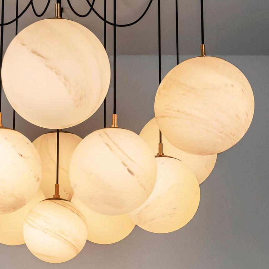 Several lit alabaster globes gathered close, warm light through veined stone