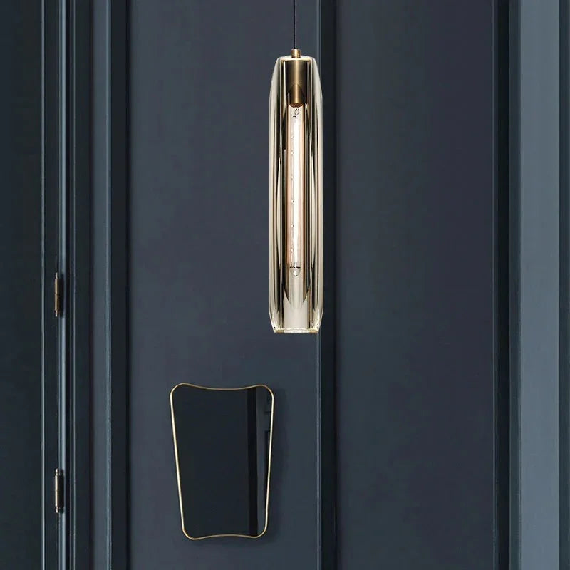 The slim pendant lit beside a deep blue door and a wood lined wall