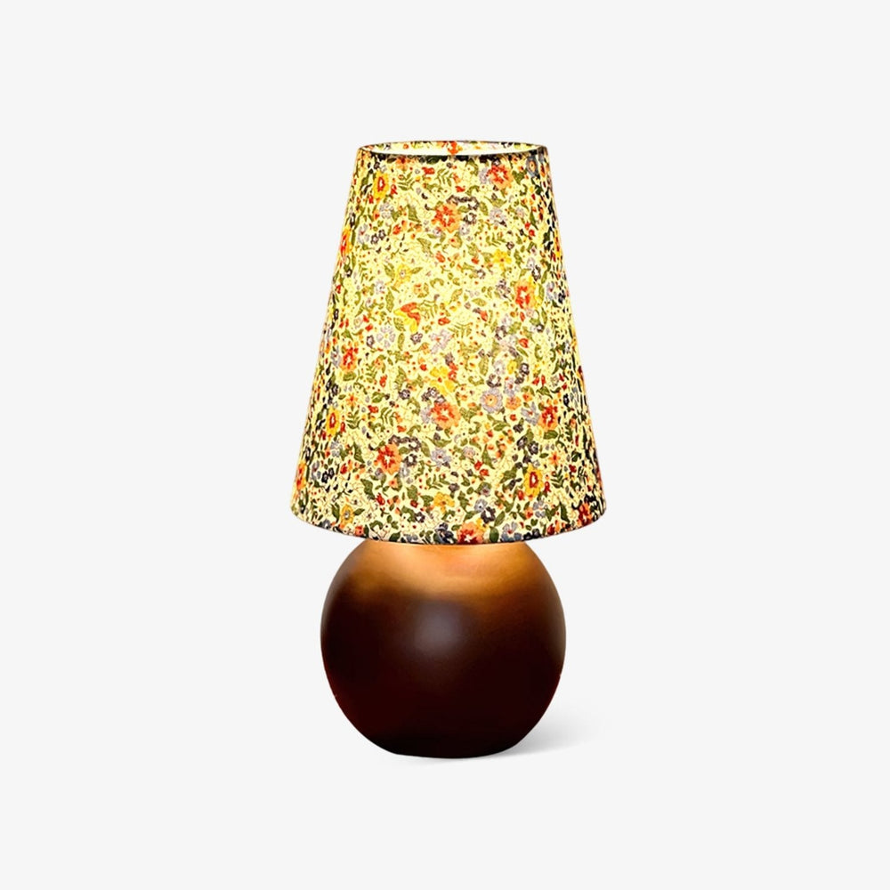 Small table lamp with a floral printed shade on a round wood ball base