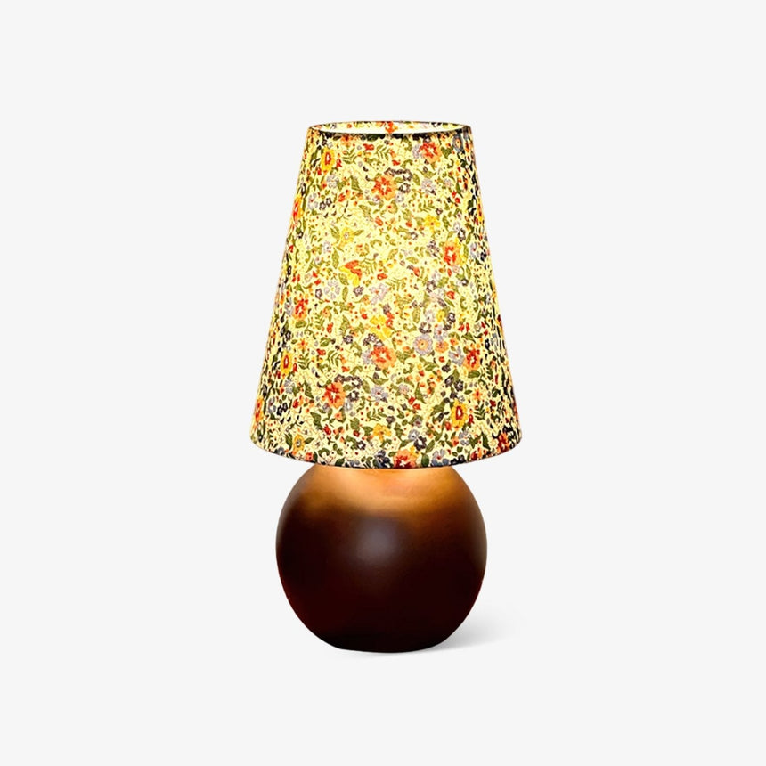 Small table lamp with a floral printed shade on a round wood ball base
