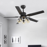 Black ceiling fan with glass globe lights in a room with framed prints
