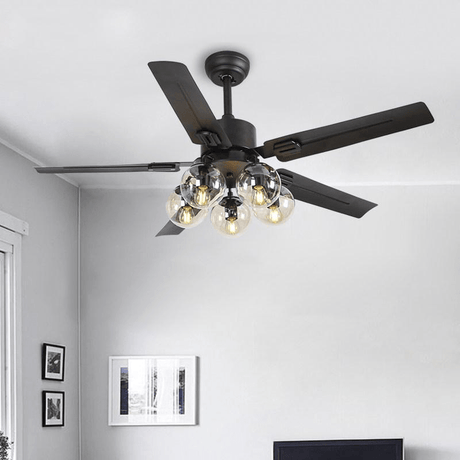 Black ceiling fan with glass globe lights in a room with framed prints