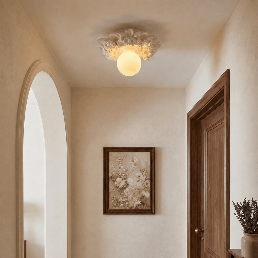 Carved floral ceiling light in a plaster hallway beside an arched opening