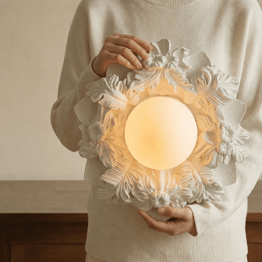 Carved floral ceiling light held in two hands to show its scale