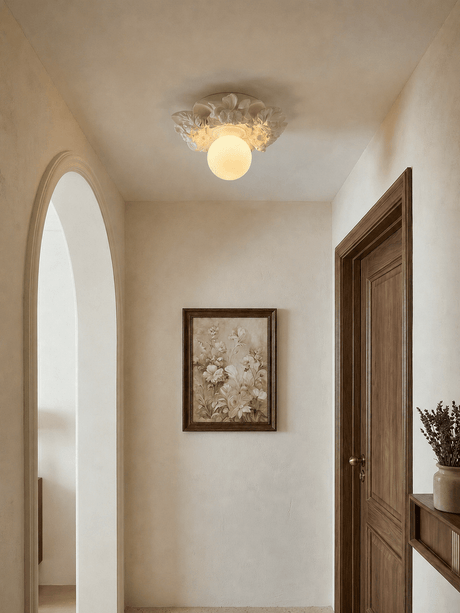 Carved floral ceiling light in a plaster hallway with a wood door