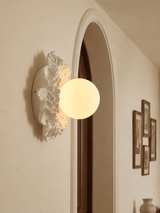 Carved floral ceiling light beside an arched doorway and framed prints