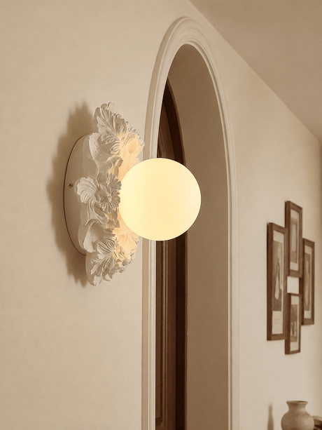 Carved floral ceiling light beside an arched doorway and framed prints