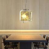 Two glass drum pendants lit above a long dining table with chairs