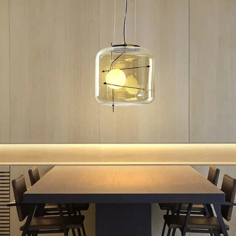Two glass drum pendants lit above a long dining table with chairs