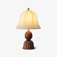 Vintage table lamp with a beige bell shade on a walnut fluted base, plain background