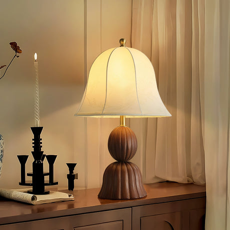 Vintage table lamp lit on a sideboard beside a black candlestick