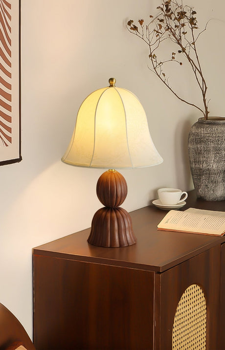 Vintage table lamp lit on a tall wooden chest in the corner of a room