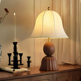 Vintage table lamp lit beside a tall lit candle and a curtain