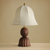 Vintage table lamp seen straight on, bell shade and fluted walnut base