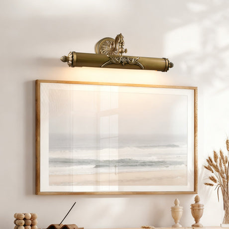 Scrolled brass bar lit above a framed seascape over a wood console