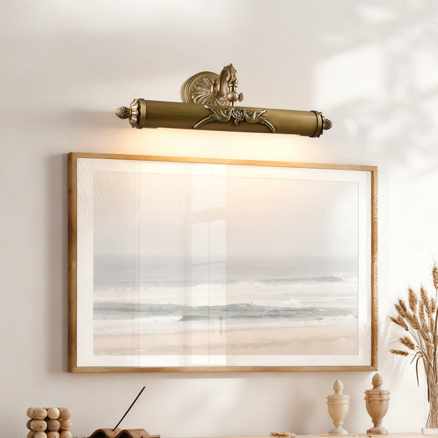 Scrolled brass bar lit above a framed seascape over a wood console