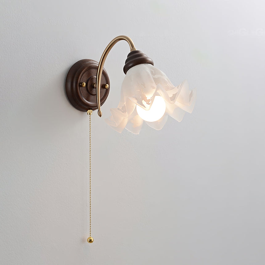 The ruffled shade unlit, seen from the front with the brass chain below it