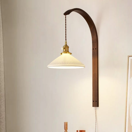 Wide white glass cone lit on the curved wood arm, the cord running down