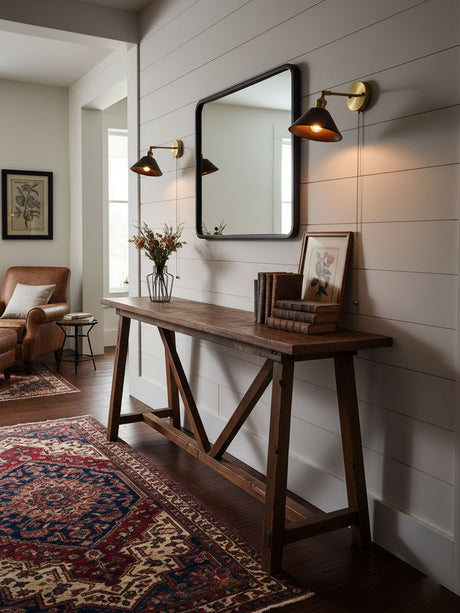Two sconces lit on either side of a mirror above a console table