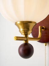 Close view of the brass arm, the wood ball finial and the glass rim
