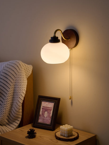 Close view of the rounded white shade and the dark wood backplate