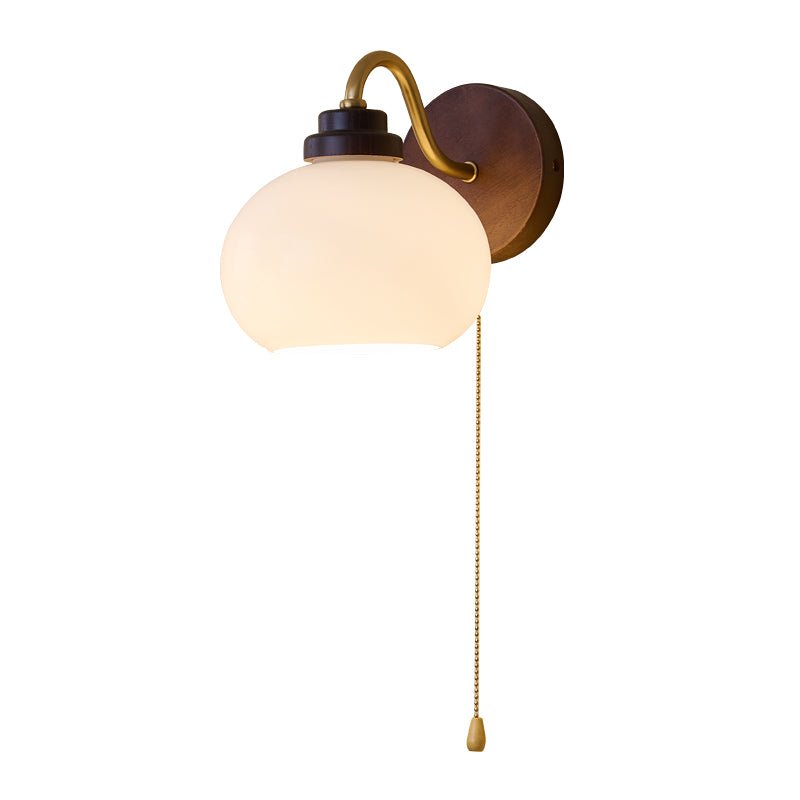 Rounded white glass shade angled down on a brass gooseneck arm
