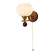 Ribbed white glass globe on a brass arm with a dark wood backplate