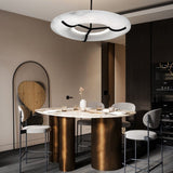 The lit stone ring above a brass kitchen island with stools and a mirror