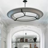 The lit ring in a white hall under an arch with shelves along the wall
