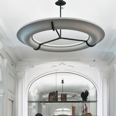 The lit ring in a white hall under an arch with shelves along the wall